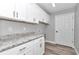 Bright laundry room with white cabinets and granite countertop at 4065 Sw 5Th Ave, Ocala, FL 34471