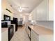 Traditional kitchen with black appliances, white cabinets, neutral countertops, and tile floors at 6184 Sw 101St Pl, Ocala, FL 34476