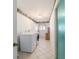 Bright laundry room features updated appliances, patterned wall trim, natural light, and neutral-colored tile flooring at 6184 Sw 101St Pl, Ocala, FL 34476