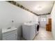 Spacious laundry room features sink, modern washer and dryer, tile flooring, and natural light from window at 6184 Sw 101St Pl, Ocala, FL 34476