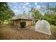 Tan house exterior with solar panels and a garden at 8465 Sw 202Nd Ter, Dunnellon, FL 34431