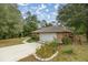 House exterior with a white garage door and landscaping at 8465 Sw 202Nd Ter, Dunnellon, FL 34431