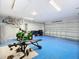 Garage with blue floor, gym equipment, and bikes at 9125 Se 47 Court Rd, Ocala, FL 34480