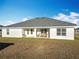 Single-story home with gray roof and backyard patio at 9125 Se 47 Court Rd, Ocala, FL 34480