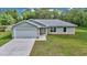 Charming single-story home featuring a light-gray exterior, attached garage, and well-maintained lawn at 963 Nw 65Th St, Ocala, FL 34475