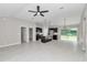Open-concept living space featuring a ceiling fan, kitchen island with seating, and sliding door access to the backyard at 963 Nw 65Th St, Ocala, FL 34475
