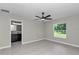 Main bedroom with ensuite bathroom, ceiling fan, and natural light from the window at 963 Nw 65Th St, Ocala, FL 34475