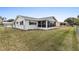 Spacious backyard featuring an enclosed porch, a well-maintained lawn and chain link fence at 9802 Se 178Th Ln, Summerfield, FL 34491