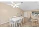 Bright dining area with white table and chairs, ceiling fan and tile floor at 9802 Se 178Th Ln, Summerfield, FL 34491