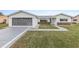 Charming single-story home featuring a two-car garage, well-maintained lawn, and a cozy front yard at 9802 Se 178Th Ln, Summerfield, FL 34491