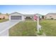 Beautiful single-story home with a two-car garage and a well-manicured lawn. American flag displayed at 9802 Se 178Th Ln, Summerfield, FL 34491