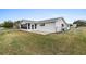 White house back with screened patio, fenced yard, and large lawn at 9802 Se 178Th Ln, Summerfield, FL 34491