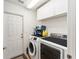 Clean laundry room, washer, dryer, and storage cabinets at 9910 Se 138Th Loop, Summerfield, FL 34491