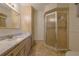 Bright bathroom featuring a granite vanity and tile shower with decorative cabinetry and neutral ceramic floors at 10185 Se 175Th Ln, Summerfield, FL 34491