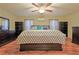 Main bedroom with wood floors, large bed, and ceiling fan at 10185 Se 175Th Ln, Summerfield, FL 34491