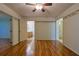 Bedroom with hardwood floors, light paint, ceiling fan, and an ensuite bathroom at 10185 Se 175Th Ln, Summerfield, FL 34491