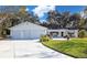 White house with two-car garage and landscaped yard at 10185 Se 175Th Ln, Summerfield, FL 34491