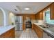Modern kitchen featuring stainless steel appliances, granite counters, and ample wood cabinets at 10185 Se 175Th Ln, Summerfield, FL 34491