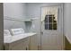 Functional laundry room with appliances and shelving, located near a door at 10185 Se 175Th Ln, Summerfield, FL 34491