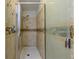 Neutral tiled walk-in shower with glass doors and built-in shelving at 10185 Se 175Th Ln, Summerfield, FL 34491