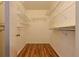A walk-in closet features built-in shelving and wood flooring for ample storage space at 10185 Se 175Th Ln, Summerfield, FL 34491