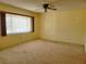 Well-lit bedroom featuring a window with curtains and ceiling fan at 10736 Sw 62Nd Ave, Ocala, FL 34476