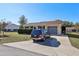 House with driveway and carport, surrounded by green landscaping at 10962 Sw 80 Ct, Ocala, FL 34481