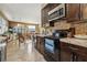 Spacious kitchen with dark wood cabinets, tile counters, and stainless steel appliances at 10962 Sw 80 Ct, Ocala, FL 34481