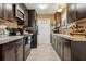 Modern kitchen with dark wood cabinets, tile backsplash, and stainless steel appliances at 10962 Sw 80 Ct, Ocala, FL 34481