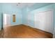 Light blue bedroom with wood flooring and a large closet at 11540 Se Highway 464, Ocklawaha, FL 32179