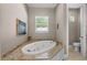 Relaxing bathroom featuring a corner soaking tub and granite countertop at 13041 Se 158Th Ln, Weirsdale, FL 32195