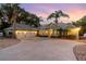 Two-car garage and house exterior, showcasing landscaping and a metal roof at 13041 Se 158Th Ln, Weirsdale, FL 32195