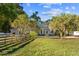 House exterior with orange trees and wooden fence at 13041 Se 158Th Ln, Weirsdale, FL 32195