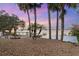 Serene lakefront view at sunset with palm trees and a private dock at 13041 Se 158Th Ln, Weirsdale, FL 32195