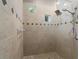 Large walk-in shower with pebble floor and decorative tile at 13041 Se 158Th Ln, Weirsdale, FL 32195