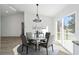 Modern dining area with a round glass table, stylish chandelier, and large windows at 15002 Sw 27 St, Ocala, FL 34481