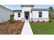 Front walkway leading to a modern entryway with dark gray door and stone accents at 15663 Sw 47Th Avenue Rd, Ocala, FL 34473