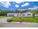 White single story home with American flag and landscaped yard at 17380 Se 98Th Cir, Summerfield, FL 34491