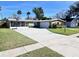 Green house with large driveway, landscaping, and basketball hoop at 2241 Brian Ave, South Daytona, FL 32119