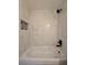 Bathroom with white bathtub and marble tile shower surround at 262 Locust Rd, Ocala, FL 34472