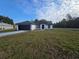 Single-story home with a dark roof, black garage door, and a well manicured lawn at 262 Locust Rd, Ocala, FL 34472