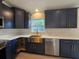 Modern kitchen with navy cabinets, stainless steel appliances, gold hardware, and a farmhouse sink at 262 Locust Rd, Ocala, FL 34472