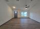 Modern living room with wood floors, ceiling fan, a gray front door, and large window at 262 Locust Rd, Ocala, FL 34472