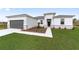 Modern house exterior with gray garage door and stone accents.Landscaped front yard at 3792 Sw 166Th Pl Rd, Ocala, FL 34473