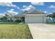 Single-story home with gray siding, attached garage, and a well-manicured lawn at 38 Spring Trce, Ocala, FL 34472