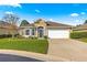 Tan one-story house with a white garage door and manicured lawn at 4 Diamond Cove Ct, Ocala, FL 34472