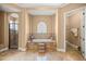 Elegant bathroom with tiled tub, step stool, decorative window and separate glass shower at 4020 Se 9Th Ave, Ocala, FL 34480