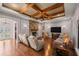 Spacious living room featuring hardwood floors, a stone fireplace, and a coffered ceiling at 4020 Se 9Th Ave, Ocala, FL 34480