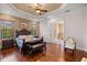 Inviting main bedroom with hardwood floors, tray ceiling, and ensuite bathroom entrance at 4020 Se 9Th Ave, Ocala, FL 34480