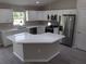 Modern kitchen featuring white cabinets, stainless steel appliances, and a large island at 5 Locust Trak, Ocala, FL 34472